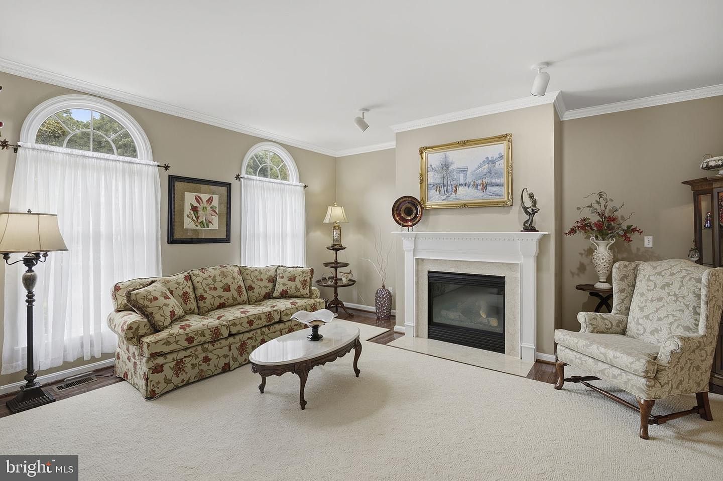 Formal living room with gas fireplace and arched windows