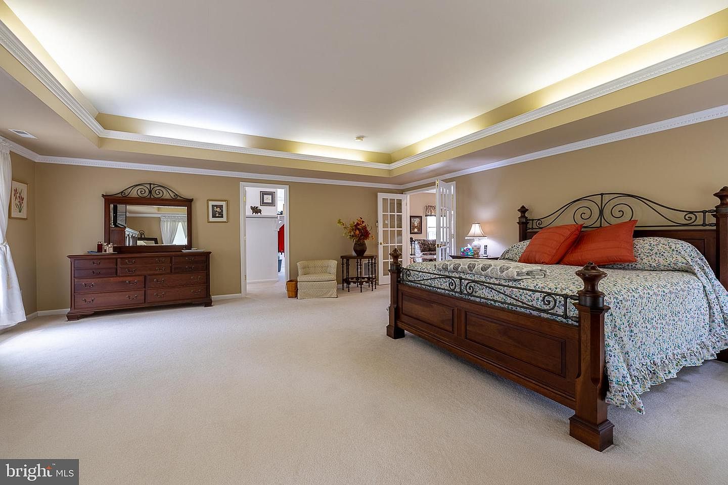 Primary suite with four-poster bed and sitting area beyond