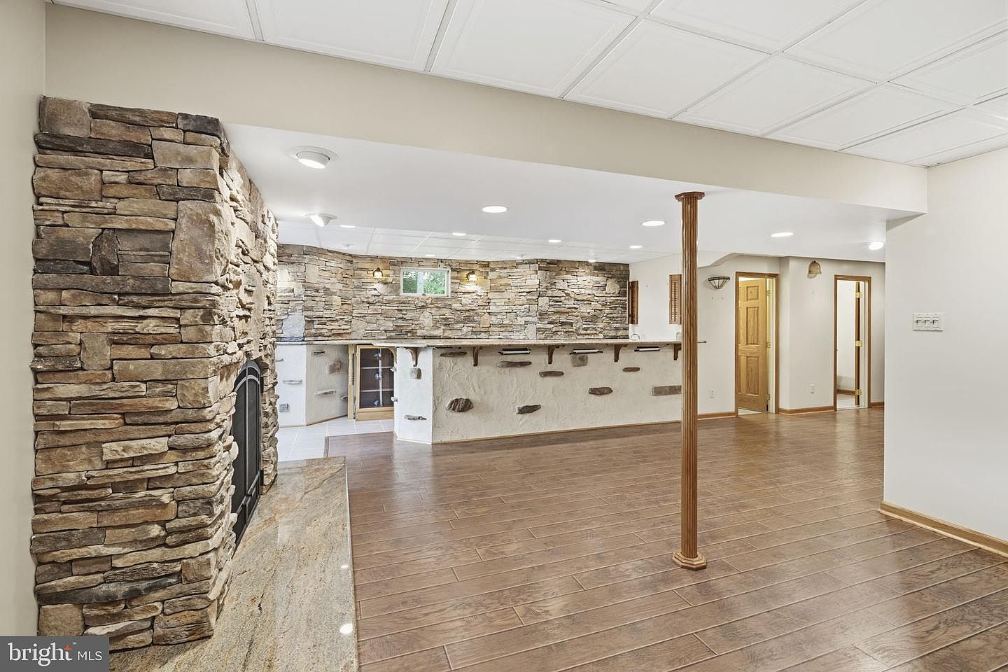 Lower-level stone fireplace and open recreation area