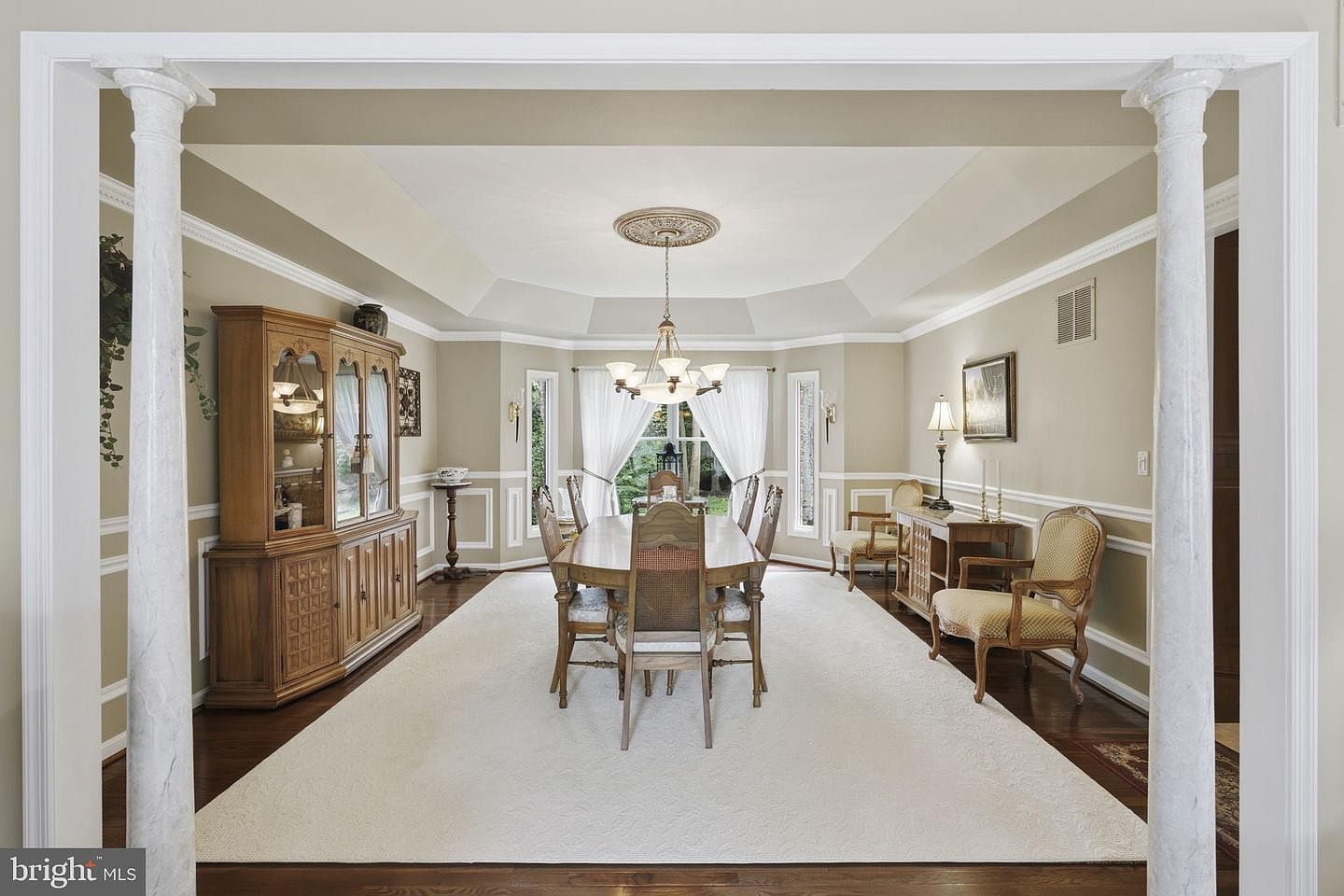 Formal dining room framed by columns with a tray ceiling