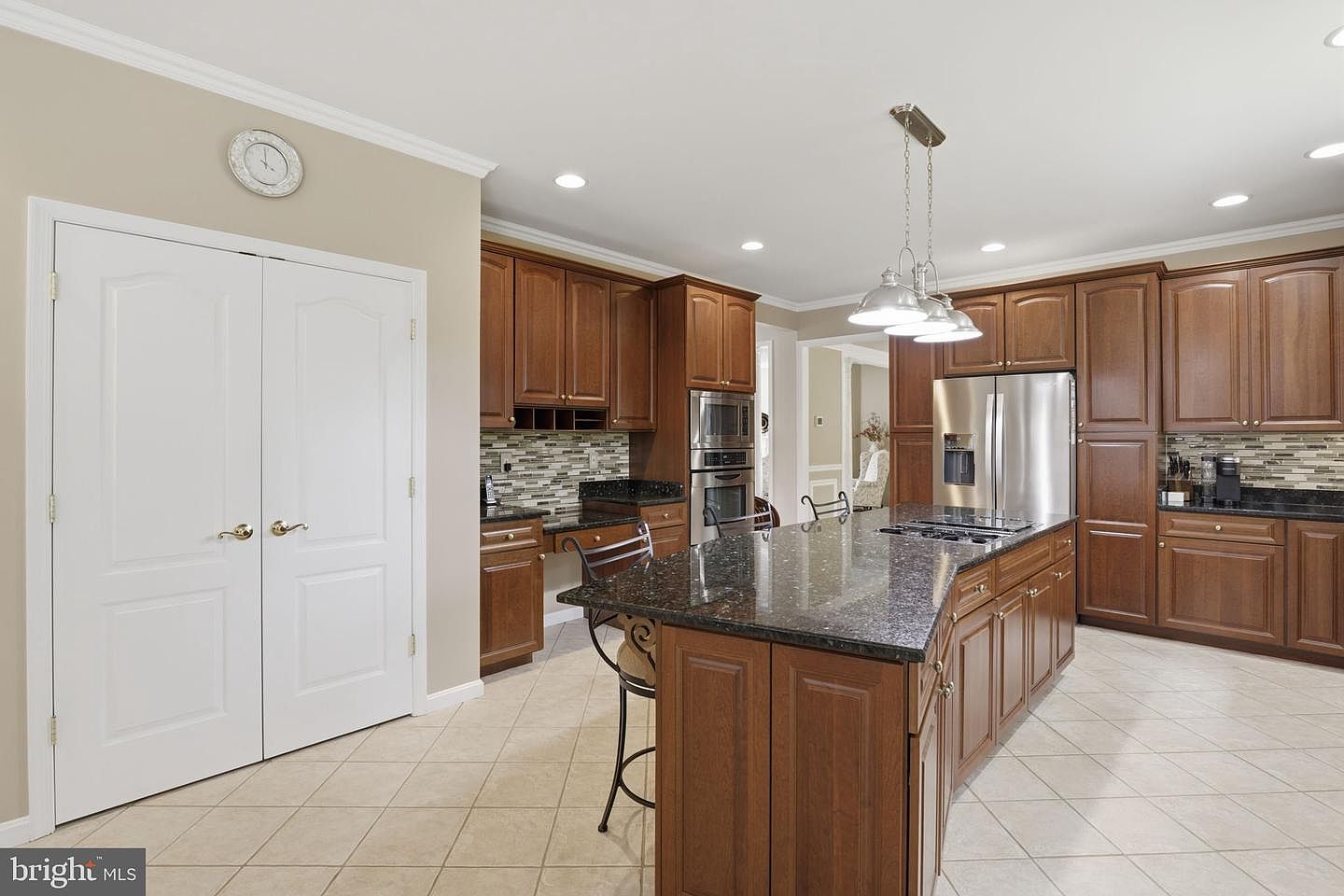 Kitchen with cherry cabinetry and a large granite island